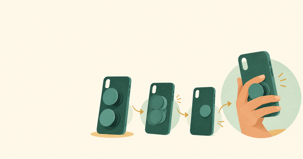 A hand using a small expanding phone grip while unused prototype parts fall away